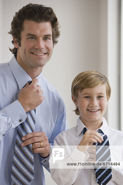 Father and son tying neckties