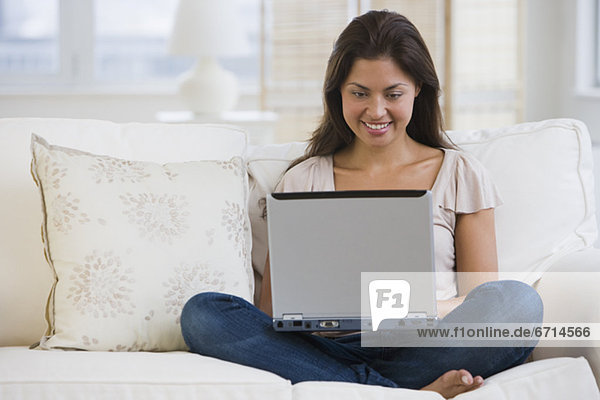 Asian woman looking at laptop