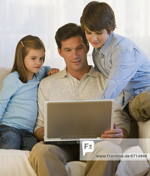 Vater und Kinder Blick auf laptop
