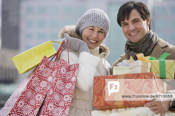 Couple carrying shopping bags and gifts