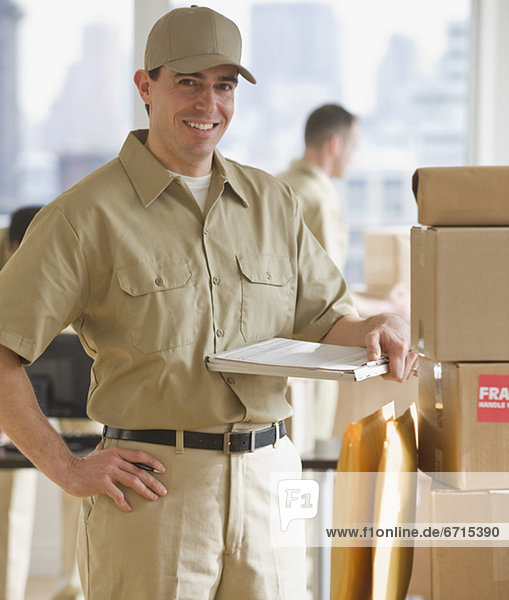 Delivery man standing next to packages