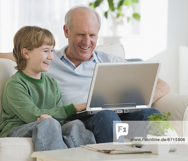 Grandfather and grandson looking at laptop