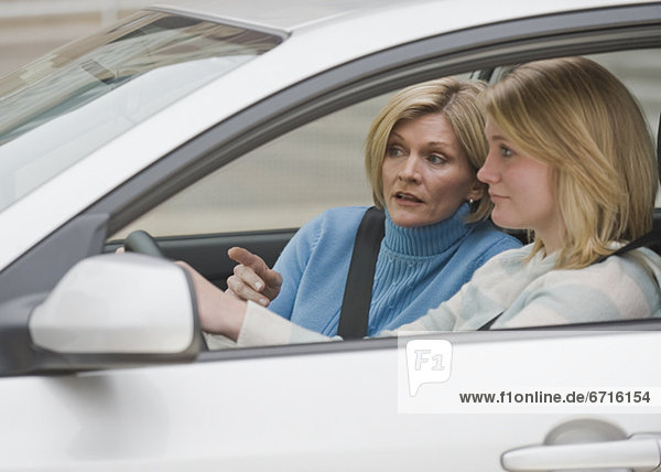 Mother teaching teenaged daughter to drive