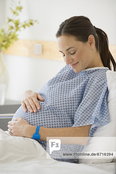 Pregnant Hispanic woman with hands on belly