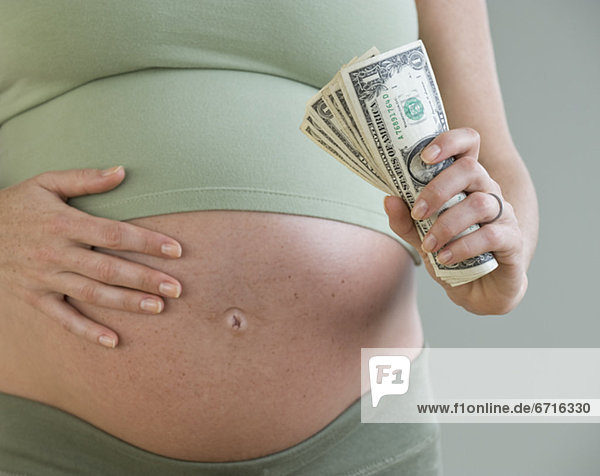 Pregnant woman holding money