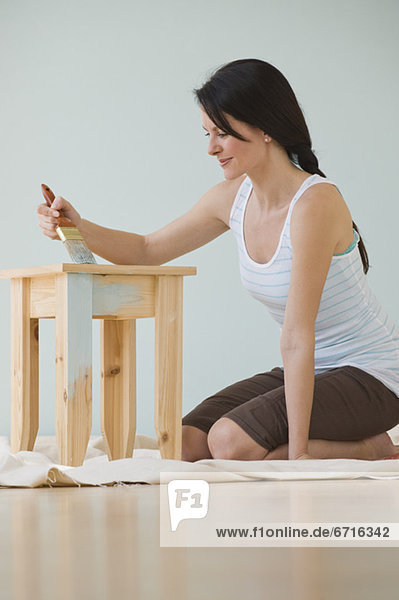Woman painting wooden table