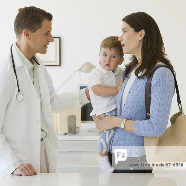 Male doctor talking to mother and son