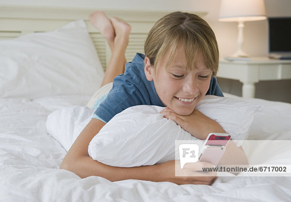 Handy benutzen Bett Mädchen