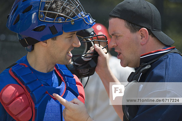 Baseball catcher arguing with umpire