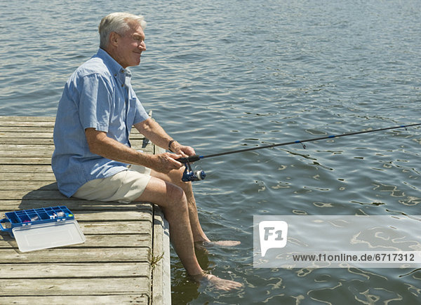 Senior man fishing off dock