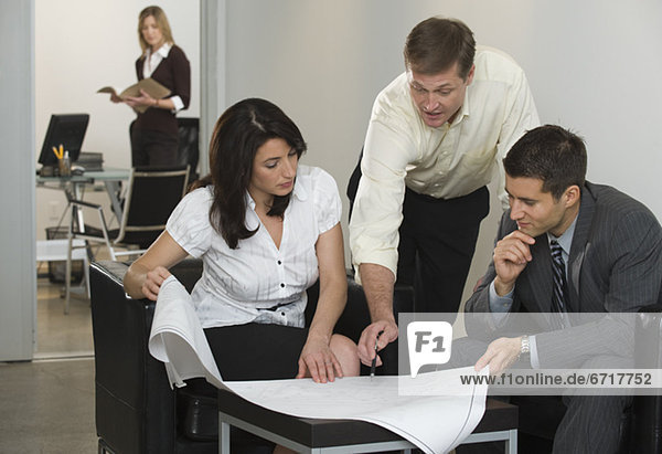 Business people examining blueprints