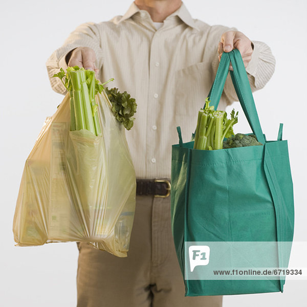 Man holding reusable grocery bags