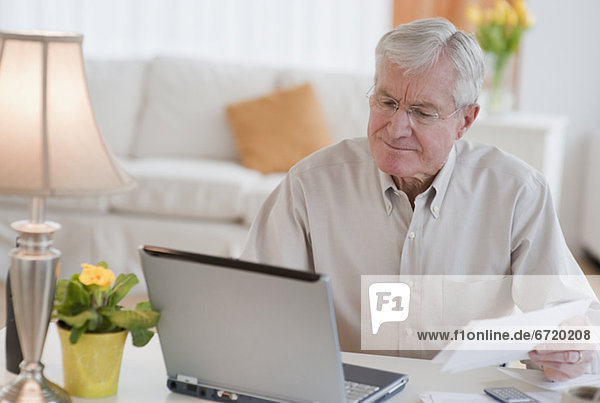 Senior man paying bills online