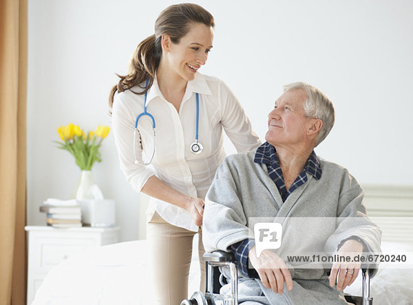 Nurse helping senior man in wheelchair