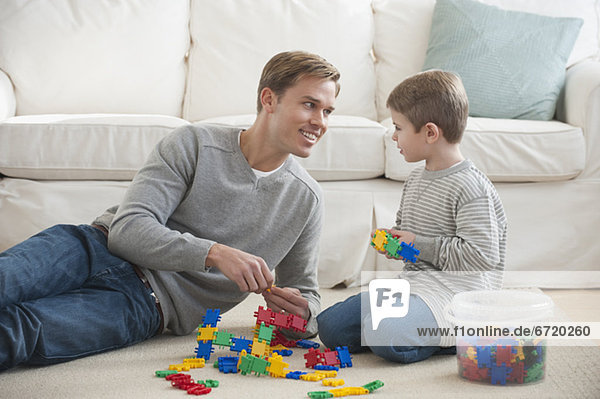 Father playing with son in livingroom