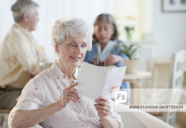Senior Senioren Frau grüßen Karte vorlesen