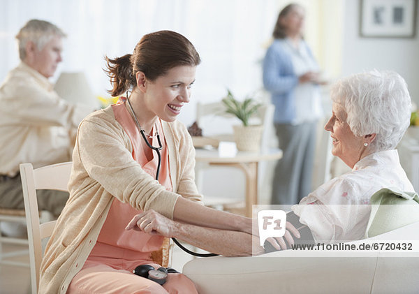 Nurse taking senior womanÕs blood pressure