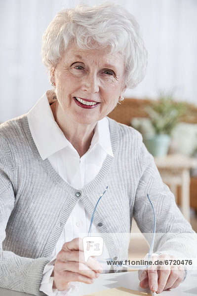sitzend Senior Senioren Portrait Frau Tisch
