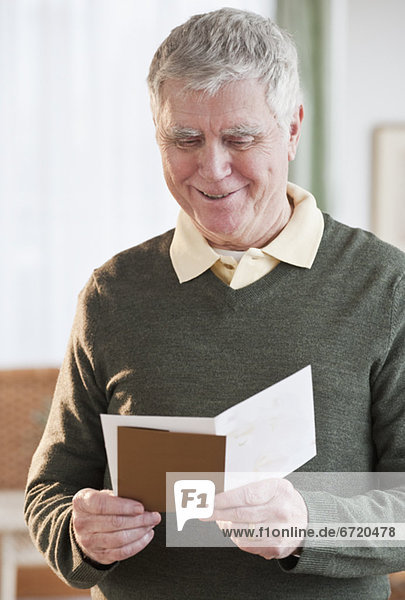 Senior Senioren Mann grüßen Karte vorlesen