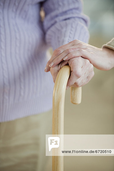 Close up of senior woman holding cane