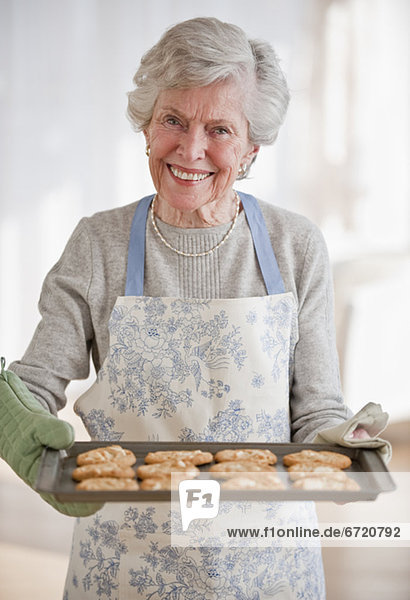 Senior Senioren Frau halten Keks gebacken