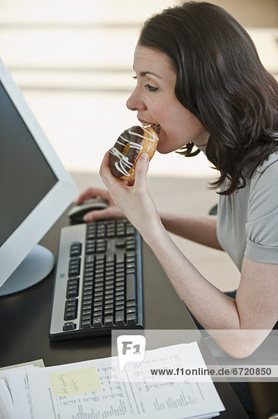 Frau  Schreibtisch  Büro  Donut  essen  essend  isst  Business