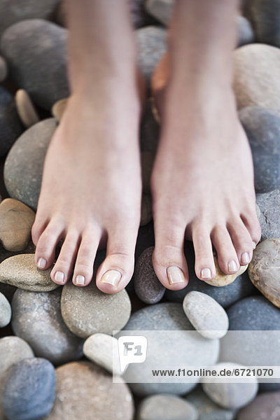 Woman's feet on pebbles
