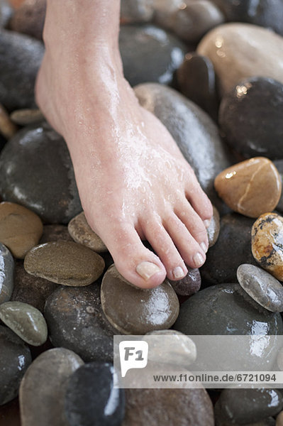 Close-up of woman's foot on pebbles