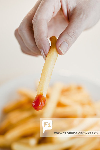 Woman with french fries  close-up of hand