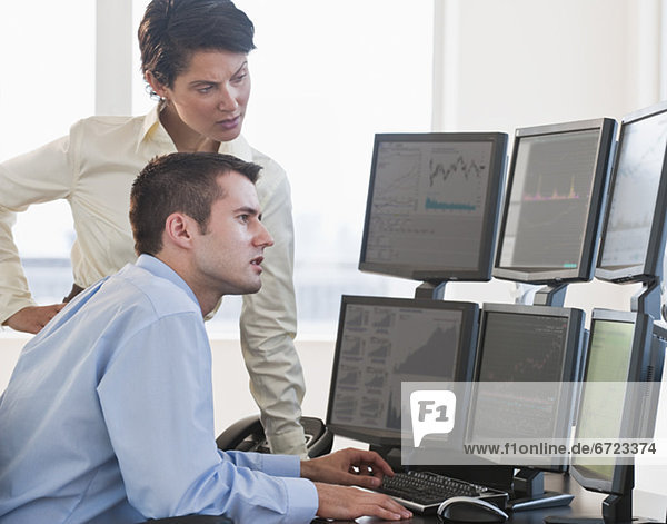 Traders studying computer screens