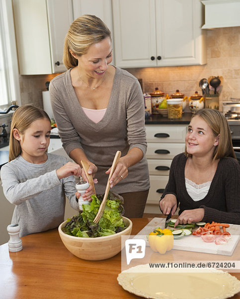 Mother and daughters making salad