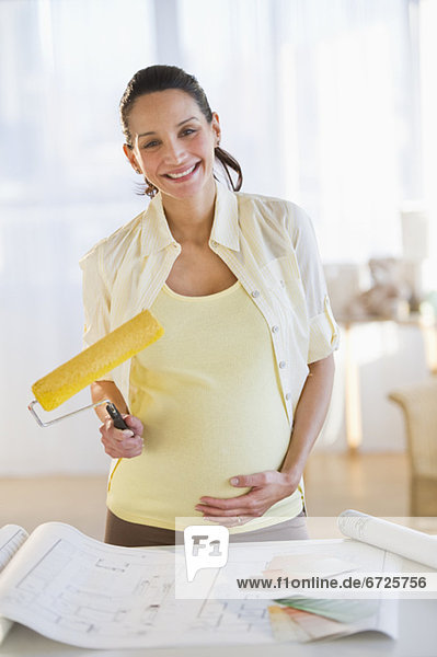 Pregnant woman holding a paint roller
