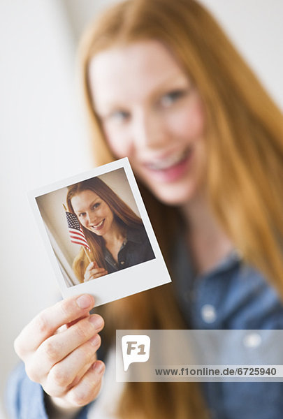 Woman holding photograph of herself