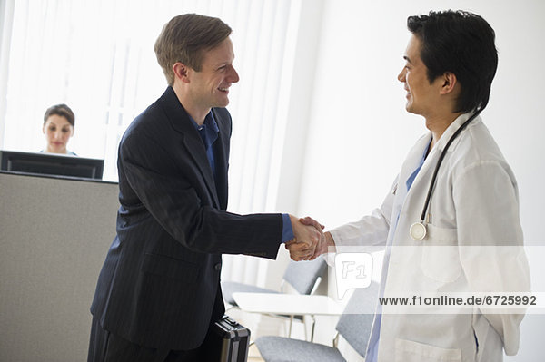 Salesman and doctor shaking hands