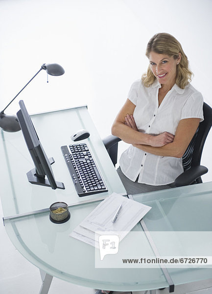 Confident businesswoman sitting at modern desk