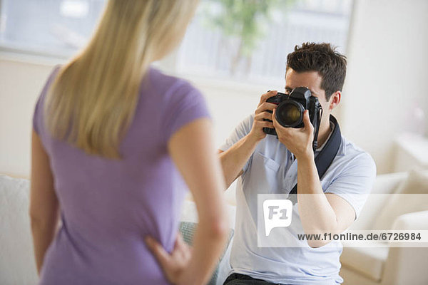 Man taking photograph of woman