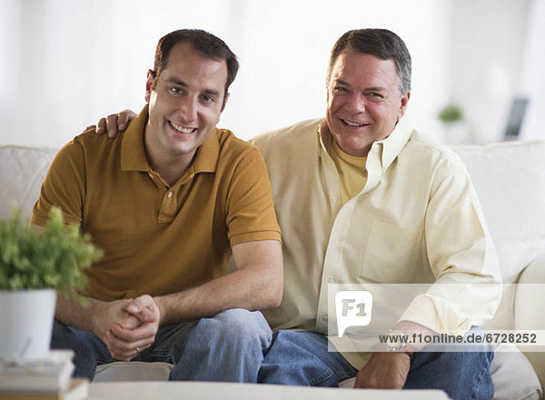 USA  New Jersey  Jersey City  Portrait of father and son sitting on sofa in living room