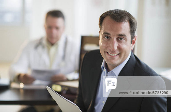 USA  New Jersey  Jersey City  Portrait of male patient holding medical results in office