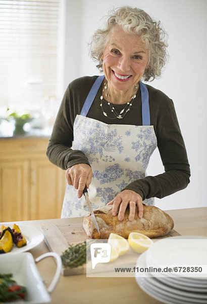 USA  New Jersey  Jersey City  Portrait of senior woman preparing food in kitchen