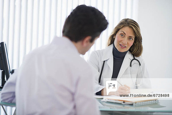 USA  New Jersey  Jersey City  Female doctor talking with male patient in office