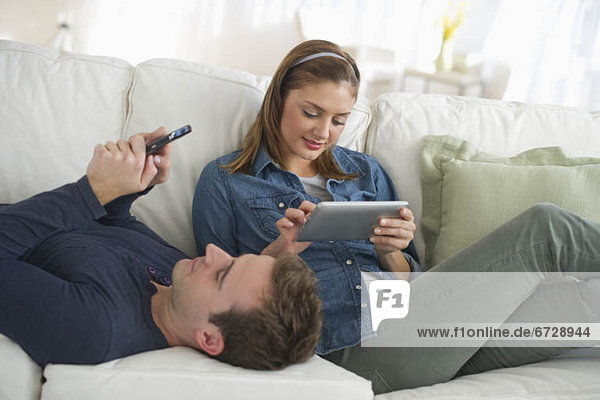 USA  New Jersey  Jersey City  Portrait of young couple relaxing on sofa