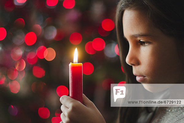 Girl (8-9) holding candle
