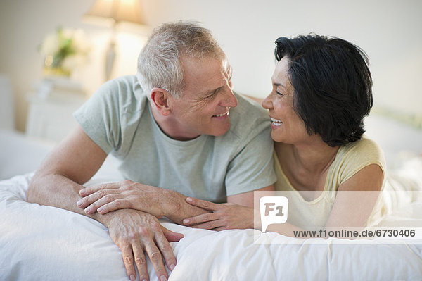 Happy mature couple laying in bed
