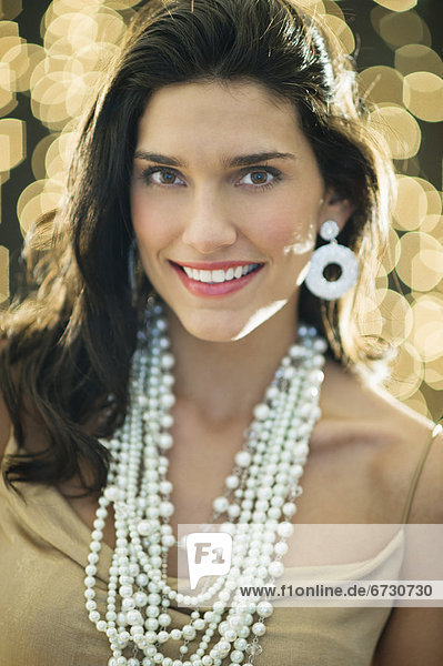 Portrait of young happy woman wearing jewelry