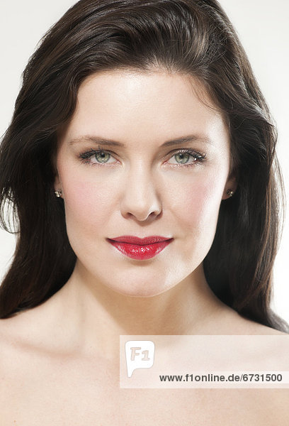 Portrait einer jungen Frau mit rot geschminkten Lippen