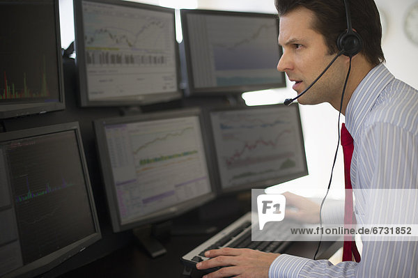 Financial worker analyzing data displayed on computer screen