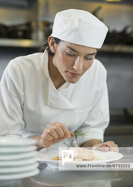 Female cook preparing food in commercial kitchen