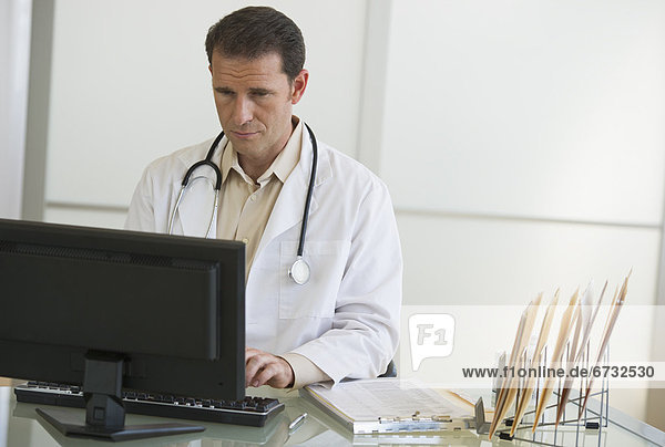 mature doctor working in office