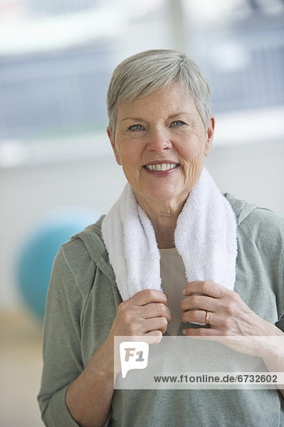Portrait of smiling senior woman in gym