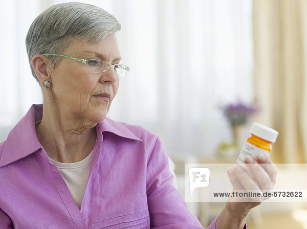 Senior woman looking at pill bottle